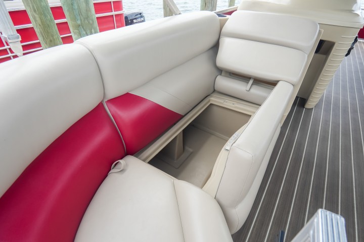 Open storage compartment under red and beige boat seat.