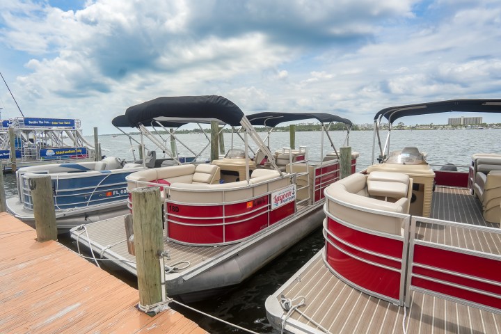 Pontoon boats docked at a marina on a cloudy day.