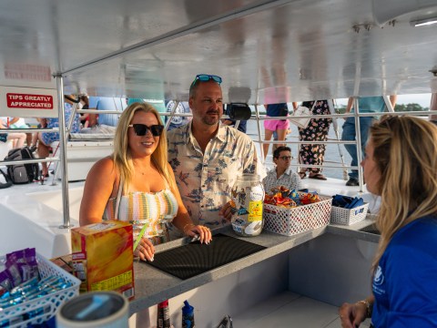 People at a boat snack bar with various treats available.